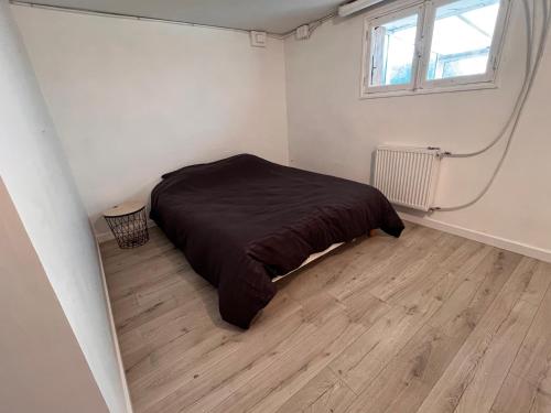 une chambre avec un lit et un parquet dans l'établissement Au petit prince, à Dole