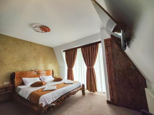 a bedroom with a bed and a staircase with windows at Villa Perule 2 Вила Перуле in Shumnatitsa