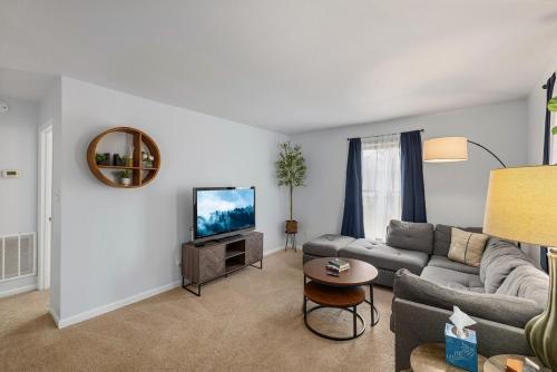 a living room with a couch and a tv at New! Special Rate for First Bookings! 2 Bedroom in Charlotte