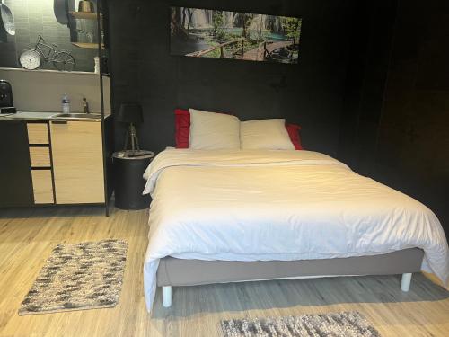 - une chambre avec un lit doté de draps blancs et d'oreillers rouges dans l'établissement Les oiseaux du paradis, à Saint-Antoine-de-Breuilh