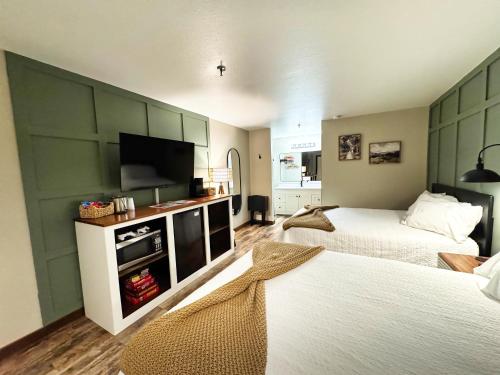 a bedroom with two beds and a flat screen tv at Jonesbones Room at White Wing Lodge- Silver Dollar City Getaway in Branson