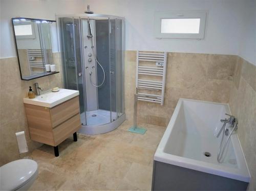 a bathroom with a shower and a sink and a tub at Bel appartement 3 pièces en villa climatisé 800m plage WIFI in Cavalaire-sur-Mer