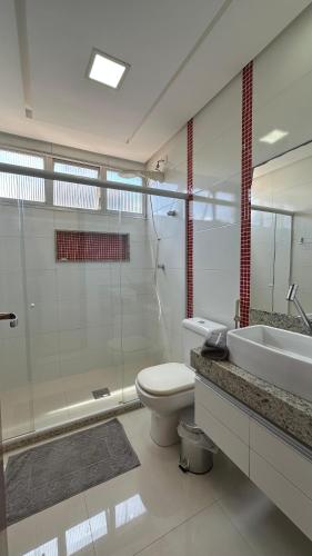 a bathroom with a toilet and a sink and a shower at PERFEITO!!! Apartamento de 3 quartos com ar-condicionado a 30 metros da Praia do Morro in Guarapari