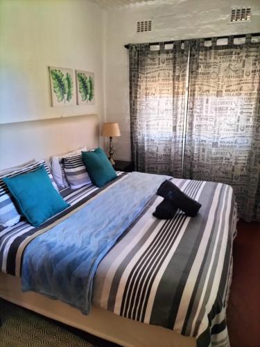 a bedroom with a large bed with blue pillows at Ocean rush turtle in Zinkwazi Beach