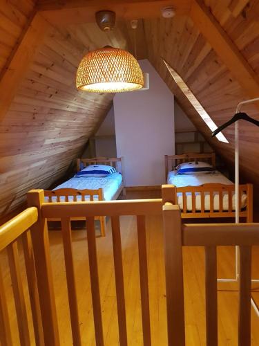 Cette chambre mansardée comprend 2 lits. dans l'établissement Maison des dunes Echappée Belle, à Barneville-Carteret