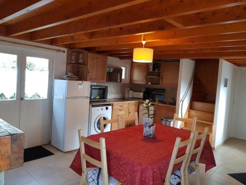 une cuisine avec une table et un chiffon rouge dans l'établissement Maison des dunes Echappée Belle, à Barneville-Carteret