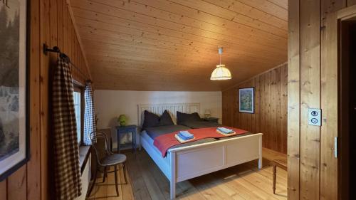 a bedroom with a bed in a wooden cabin at Müllerhus in Kandersteg