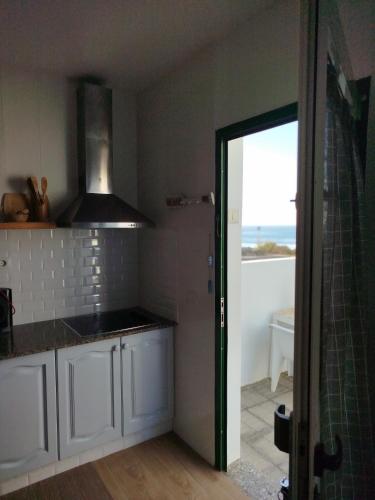 a kitchen with white cabinets and a view of the ocean at Casa Sebadal in La Santa