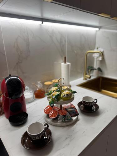 - un comptoir de cuisine avec 2 tasses et une bouilloire dans l'établissement Mirazur, à Nice