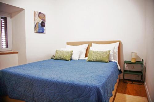 a bedroom with a bed with a blue comforter and pillows at Actor Apartment in Čilipi