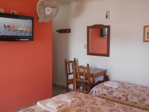 a bedroom with a bed and a tv on the wall at Dennisse Hotel in Victoria