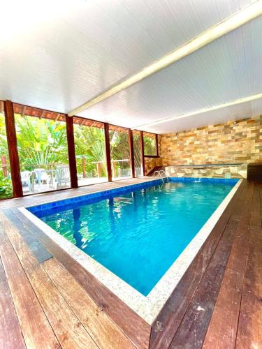 a large swimming pool in a house with windows at Pousada Cipó Prata in Serra do Cipo