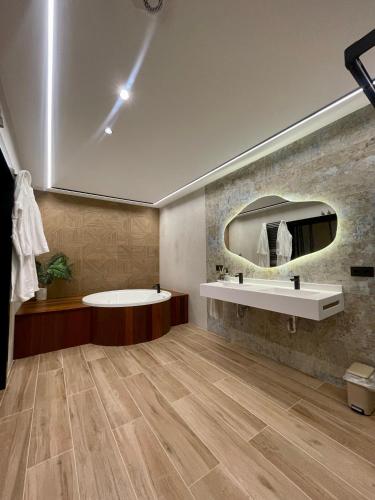 a bathroom with a tub and a sink and a mirror at Hotel La Barrosa in Abejar