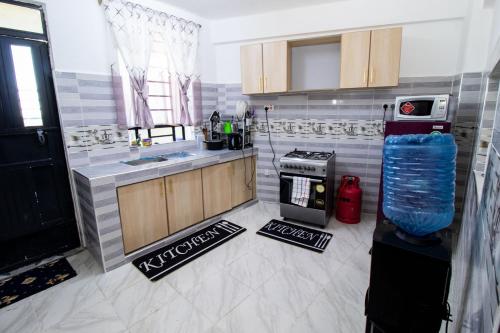 a kitchen with a sink and a stove at Charme Nest in Nanyuki