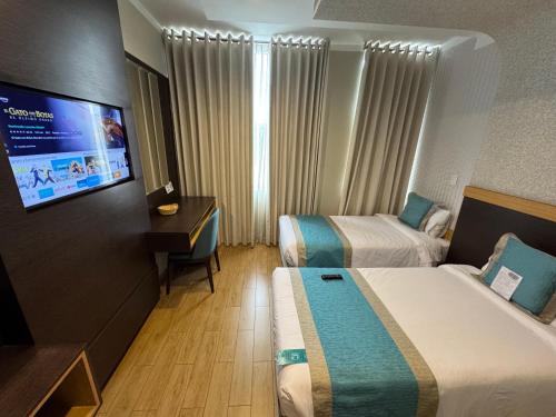 a hotel room with two beds and a flat screen tv at Hotel Diamond Lima in Lima
