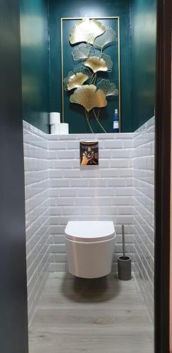 La salle de bains est pourvue de toilettes blanches et d'un mur bleu. dans l'établissement Joli studio au Ponant avec parking, à La Grande Motte