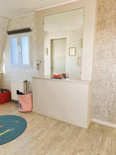 La salle de bains est pourvue d'un grand miroir et d'un comptoir. dans l'établissement Appartement Marceau, à Mers-les-Bains