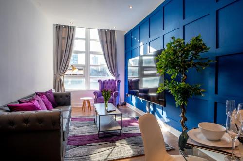 a living room with blue walls and purple furniture at Manchester City Haven in Manchester