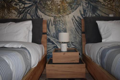 Un dormitorio con dos camas y una lámpara en una mesita de noche. en Christina's Apartment, en Nauplia