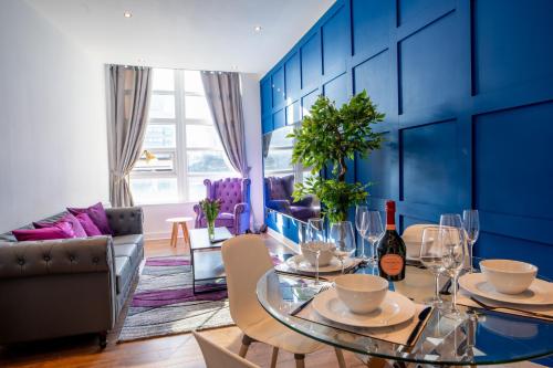 a living room with a table and a blue wall at Manchester City Haven in Manchester