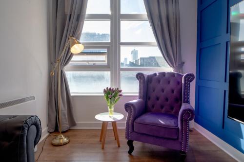 a purple chair in a room with a window at Manchester City Haven in Manchester