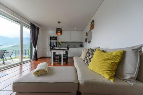 a living room with a couch and a kitchen at Gerês Country Stays- FLOR - Comfort and tranquility with a stunning view in Geres