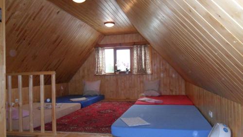 Una habitación abuhardillada con dos literas y una ventana. en Sauna&Relax, en Sakstagals