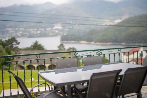 a table and chairs on a balcony with a view at Gerês Country Stays- FLOR - Comfort and tranquility with a stunning view in Geres