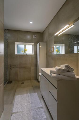 a bathroom with a shower and a sink with towels at Gerês Country Stays- FLOR - Comfort and tranquility with a stunning view in Geres