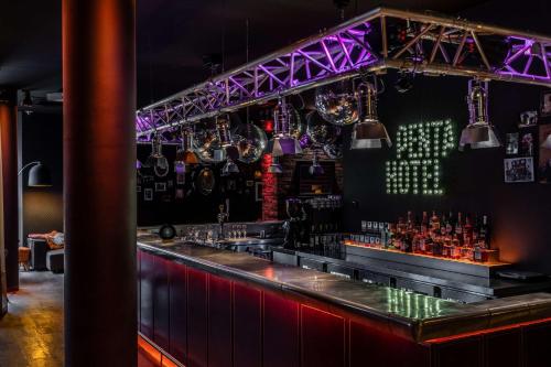 a bar with a red counter and purple lighting at pentahotel Leuven in Leuven