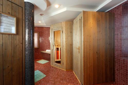 a bathroom with wood paneling and a red brick wall at Hotel Villa Argentina in Cortina dʼAmpezzo