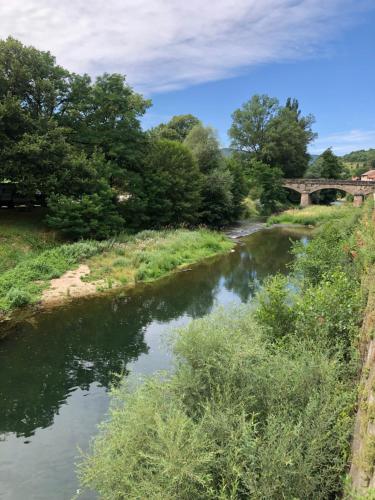 a river with a bridge in the background at La Maison de Georgette in Versols-et-Lapeyre