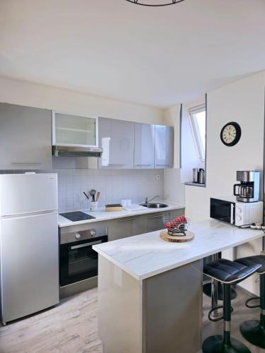 une cuisine avec des appareils électroménagers blancs et un comptoir blanc dans l'établissement Le nid de la mésange Parking Gratuit, à Blois