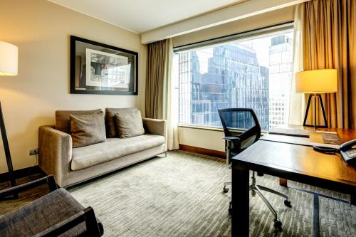 a hotel room with a couch and a desk and a window at DoubleTree by Hilton Santiago - Vitacura in Santiago