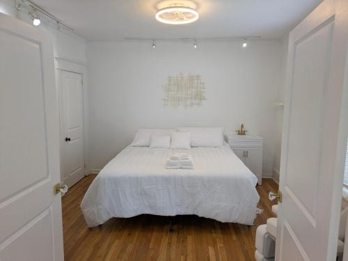 a white bedroom with a large bed with white sheets at Juliana Spa Suite - Entire Main Apartment in Winchester