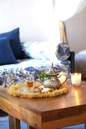 a coffee table with a tea pot and cookies on it at Riad Anyssates in Marrakech