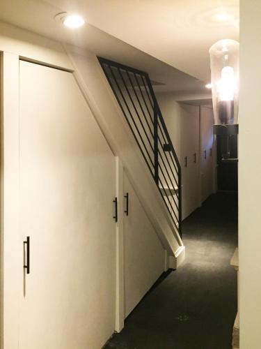 a hallway with a staircase and a white door at JC Moroccan Hideaway in Jersey City