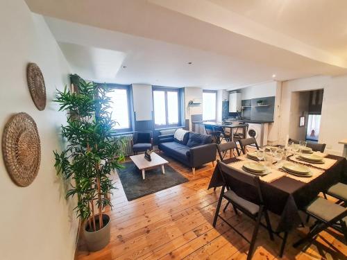 un salon avec une table et un canapé dans l'établissement Grand Appartement 3 Chambres, à Saint-Étienne