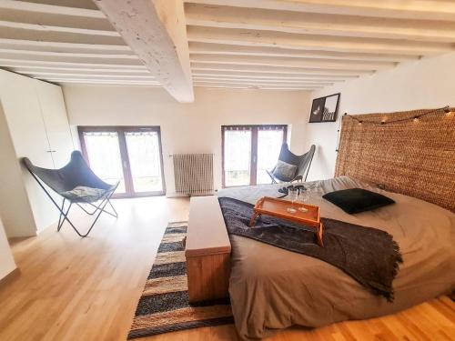 une chambre avec un grand lit et deux chaises dans l'établissement Grand Appartement 3 Chambres, à Saint-Étienne