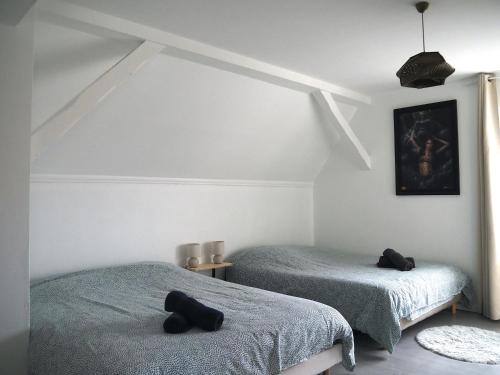 - une chambre avec 2 lits et des serviettes noires dans l'établissement l'Echappée belle Le Duplex Proche 