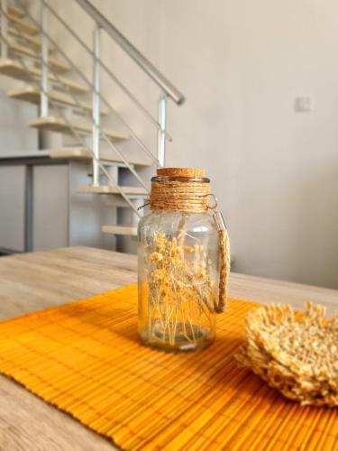 a glass jar with flowers in it sitting on a table at Duplex Family Apartment in Skopje