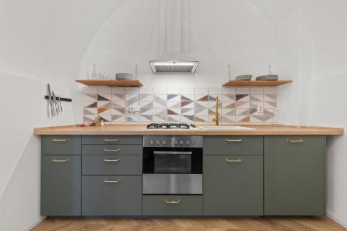 a kitchen with gray cabinets and a stove top oven at Rustic Vineyard House in Modra