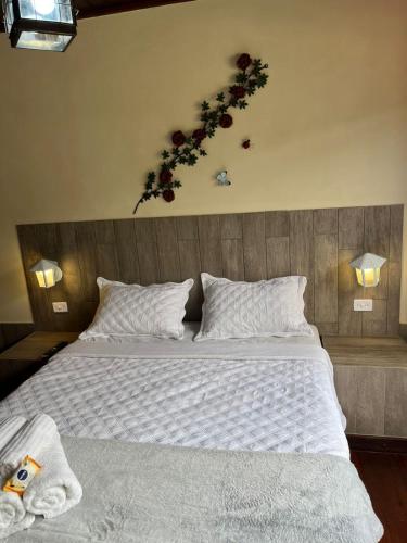 a bedroom with a large bed with a flower arrangement on the wall at Recanto dos Vianas in Teresópolis