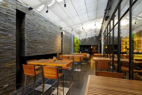 a restaurant with wooden tables and chairs and a brick wall at DoubleTree by Hilton Santiago - Vitacura in Santiago