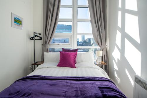 a bed in a room with a large window at Manchester City Haven in Manchester