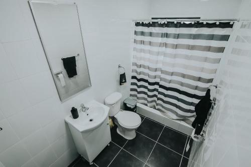 a white bathroom with a sink and a toilet at Cabañas Altos del Volcán in Villarrica