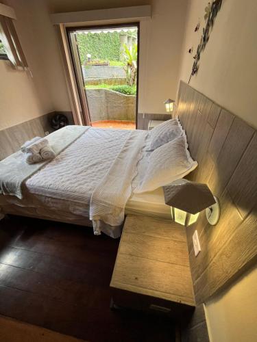 a bedroom with a large bed with a window at Recanto dos Vianas in Teresópolis