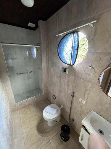 a bathroom with a toilet and a shower and a window at Recanto dos Vianas in Teresópolis
