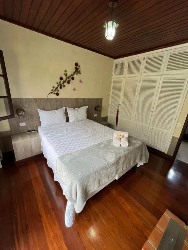 a bedroom with a large bed with white sheets at Recanto dos Vianas in Teresópolis