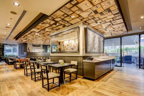 a restaurant with tables and chairs and a ceiling at DoubleTree by Hilton Santiago - Vitacura in Santiago